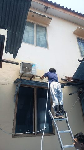 Teknisi Saujana Karya mencuci unit outdoor AC